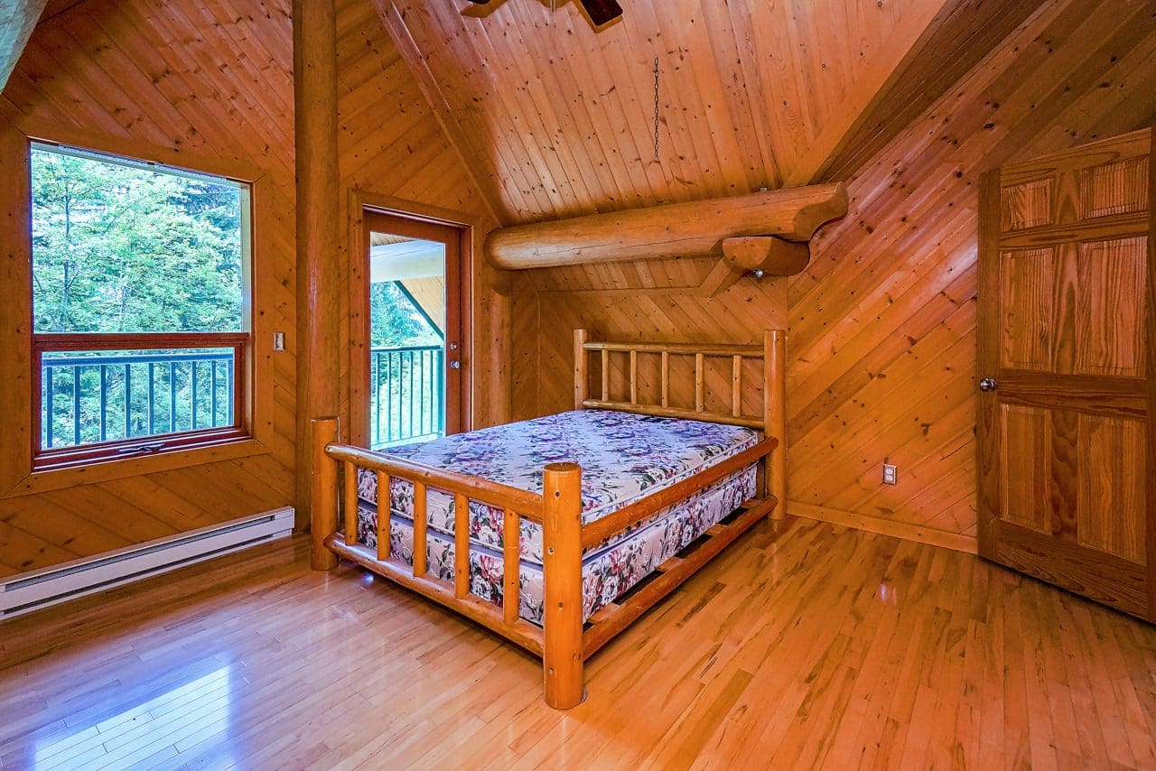 Bedroom of BC Home Builders Custom Full Scribe Log Home.