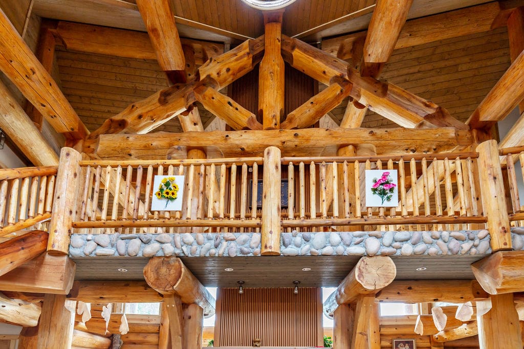 Post and beam log home interior with log railings and beams.